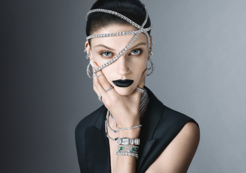A person with black lipstick and jewelry on her face Description automatically generated