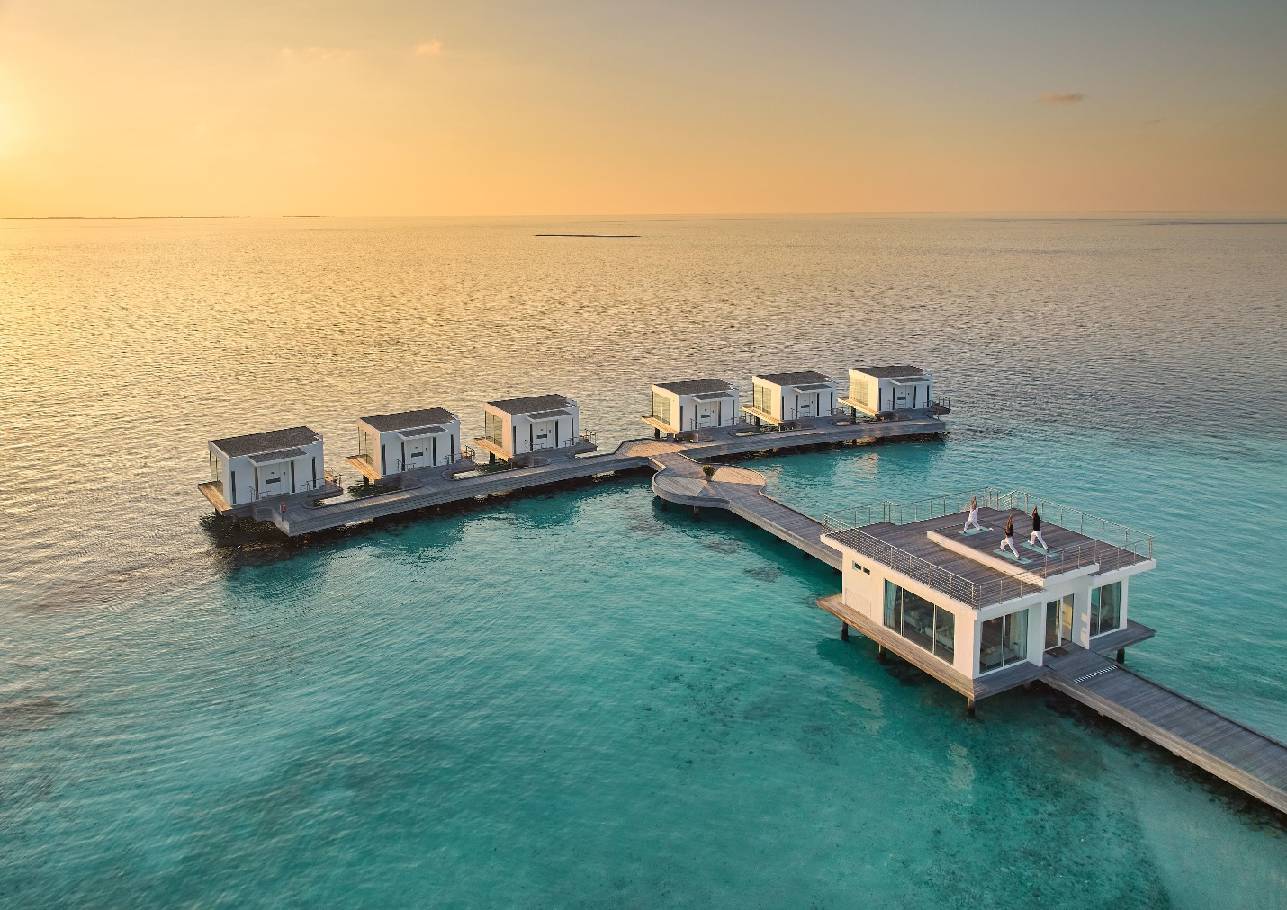 A group of houses on a dock in the ocean AI-generated content may be incorrect.